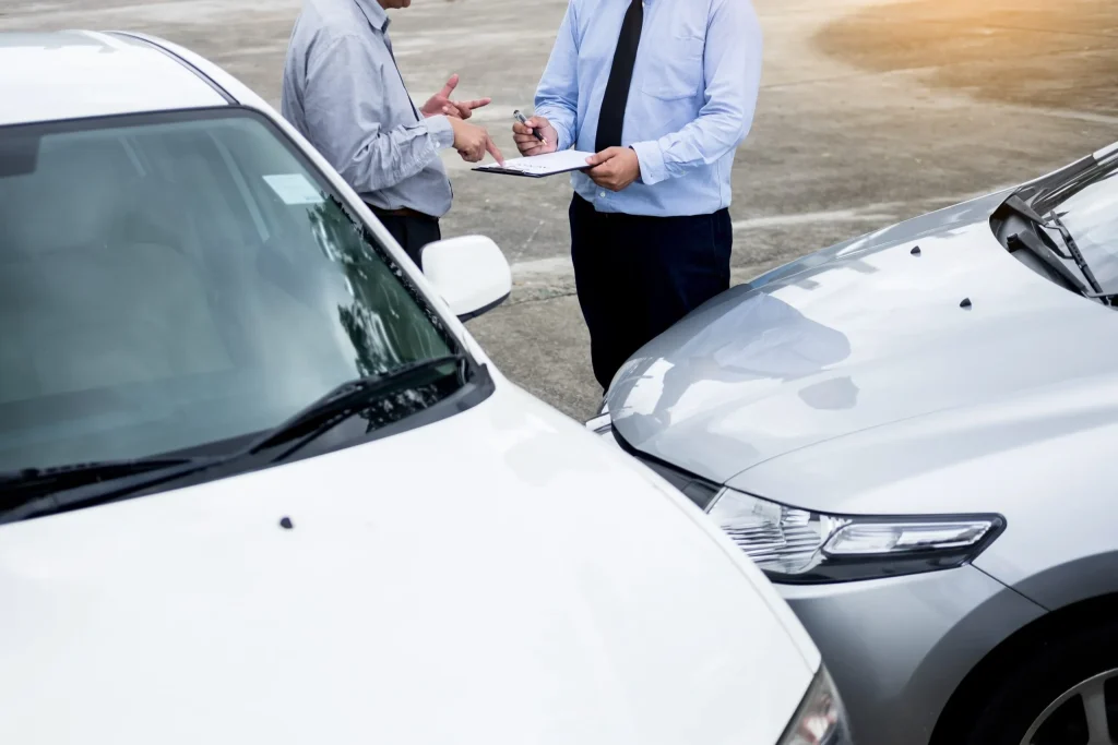 An insurance adjuster and a driver discussing fault in a car accident where he was partially at fault.