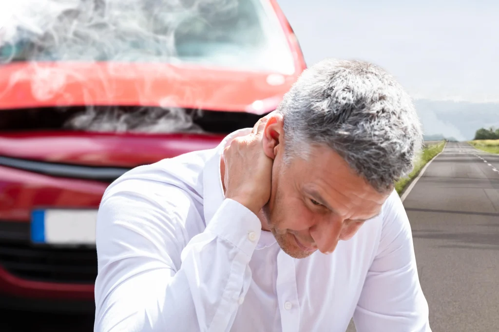 A man holding his neck in pain after a car accident.