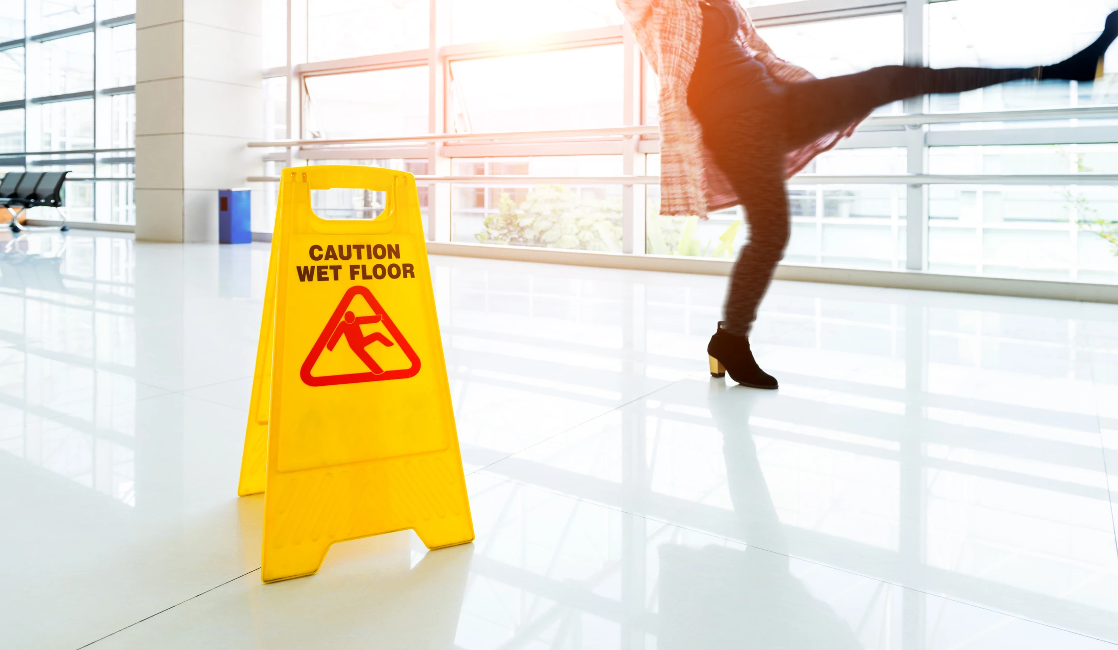 A slip and fall sign with a woman slipping in the background.