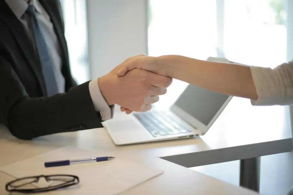 Personal injury attorney shaking female client's hand.