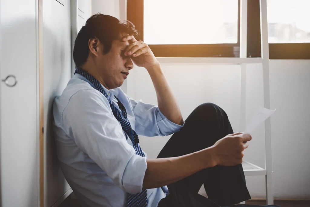 Stressed man looking at insurance letter.