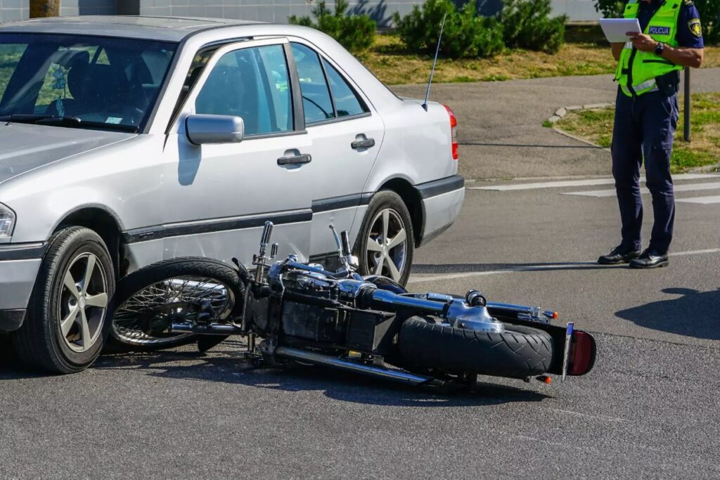 A motorcycle hit by a car on the road.