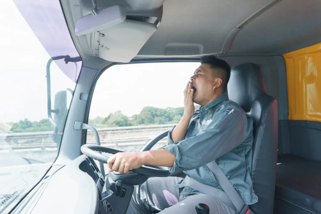 A yawning truck driver who has driven too long.